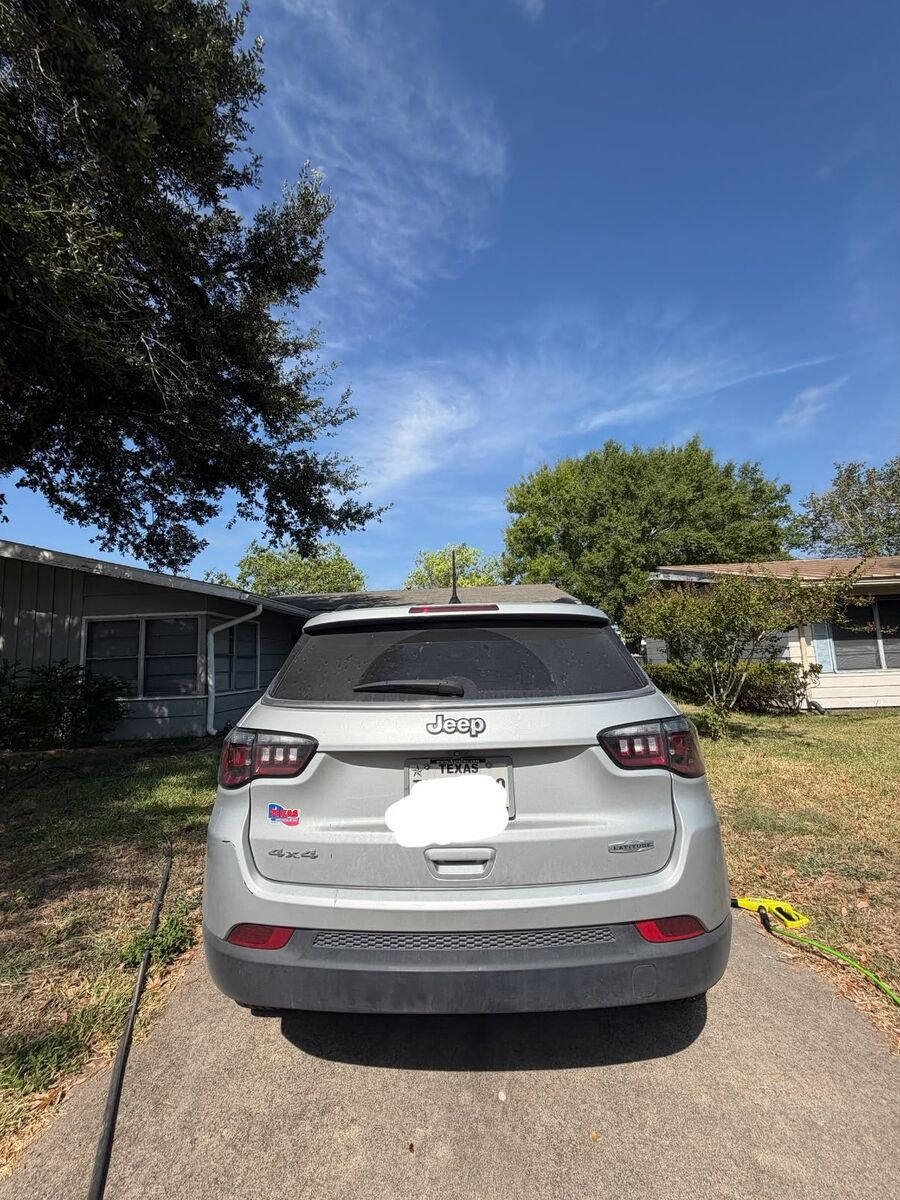 Rear of a silver Jeep Compass in a driveway