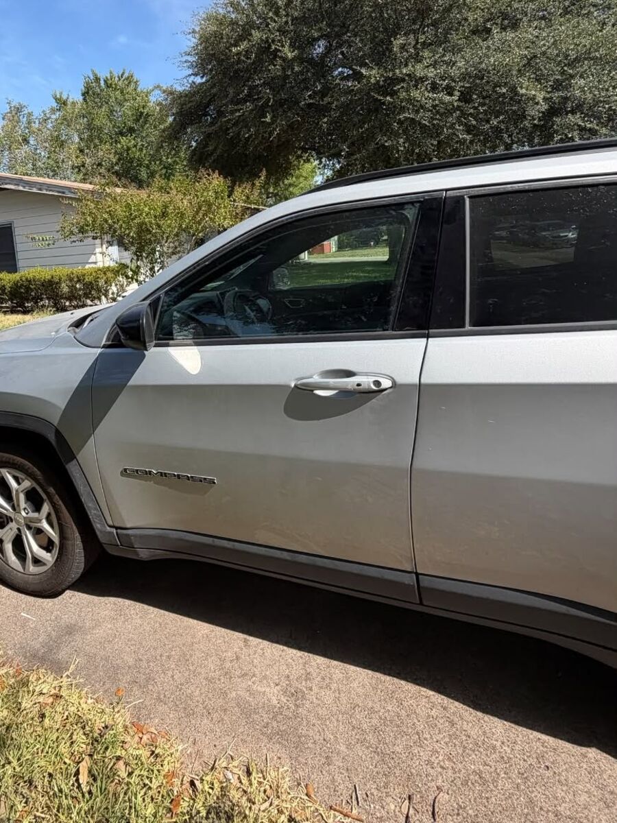 Side of a silver Jeep Compass after a wash